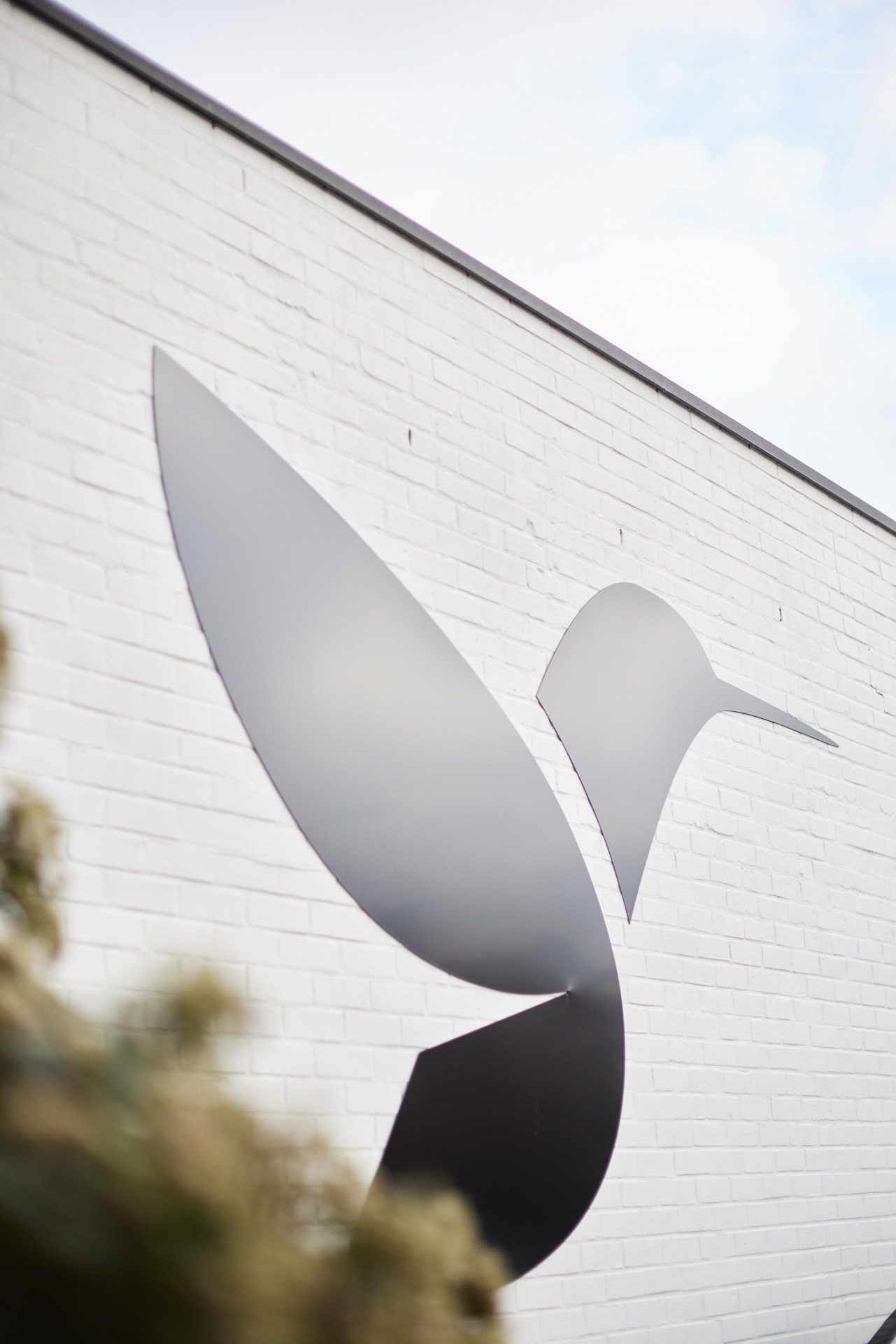 Visual van de gevel van het gebouw van Hummingbirds waarop het logo te zien is.