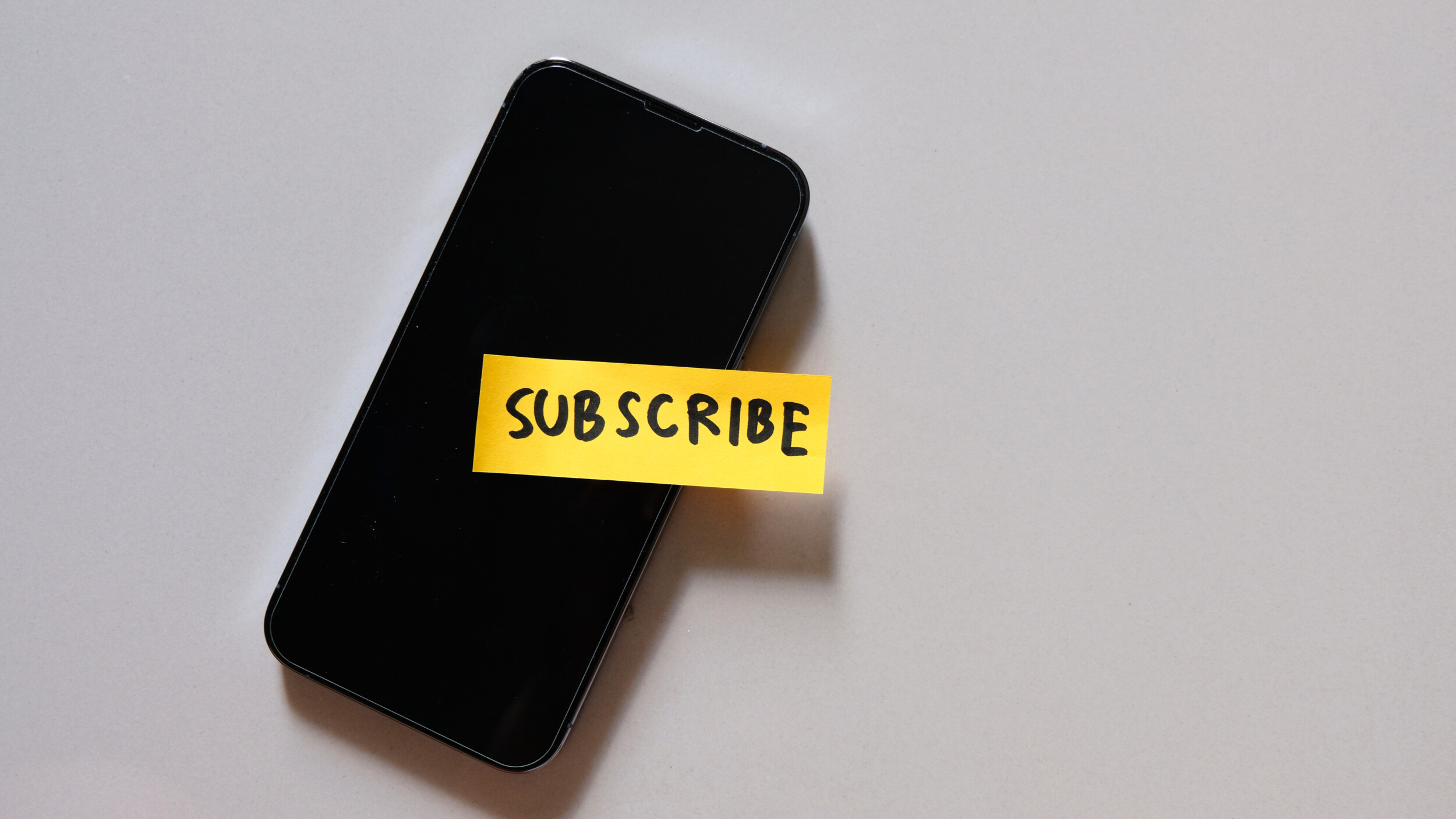 Visualisatie van een GSM met een subscribe sticker op.