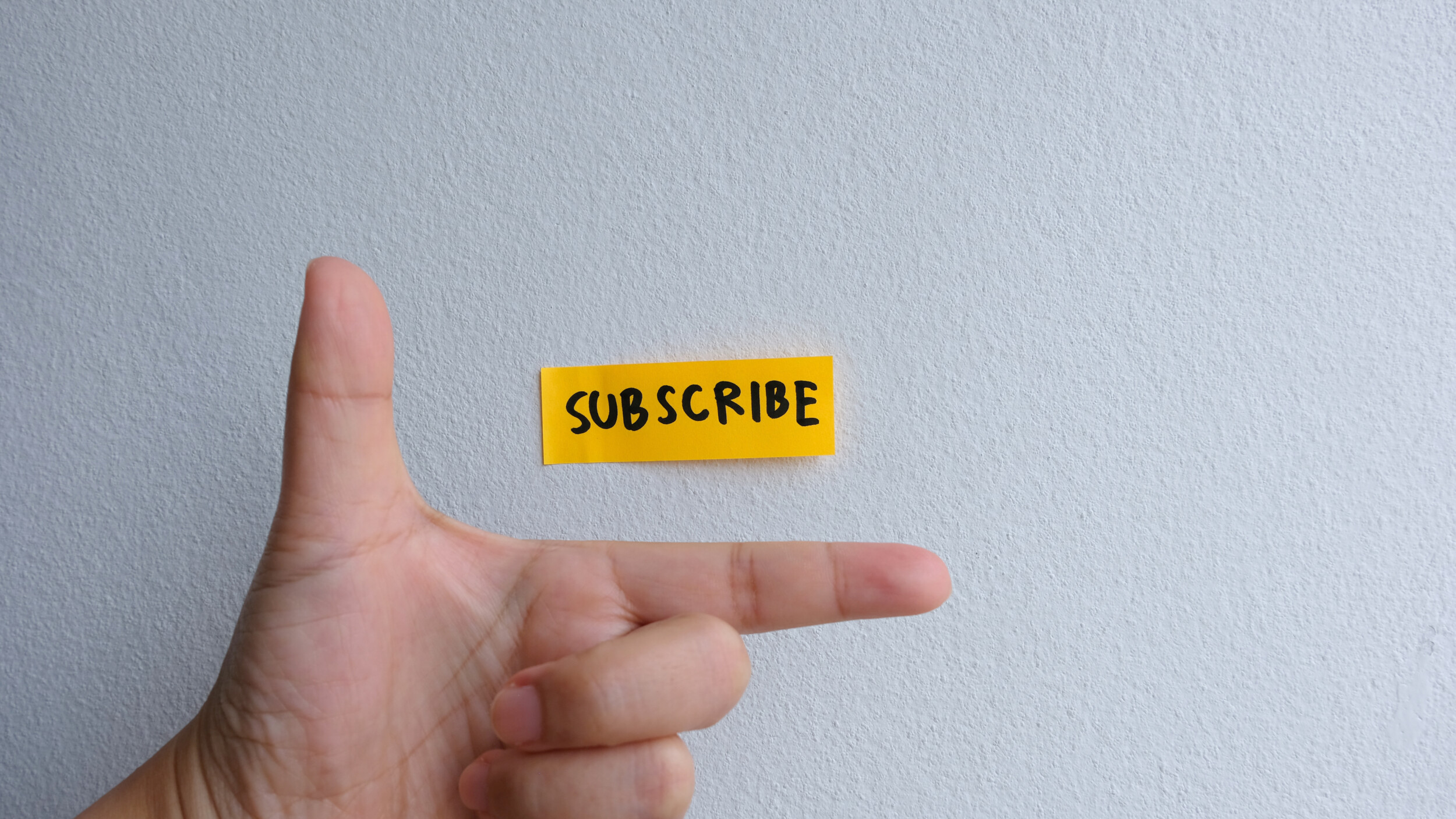 Visualisatie van een hand met een sticker erboven waarop geschreven staat: subscribe.