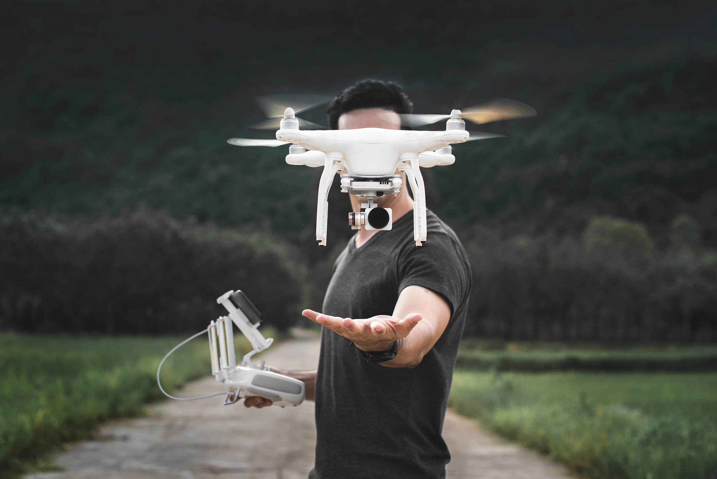 Visual van een meneer die met een drone vliegt.